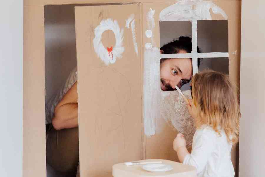 Папа и дочка раскрашивают картонный домик